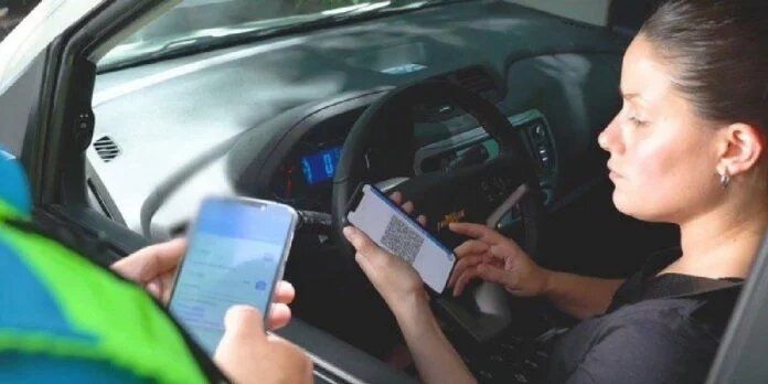 agente de tráfico escribiendo una sanción a una mujer por usar el teléfono móvil